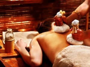 Immagine di una persona che riceve un massaggio ayurvedico, con linclusione di olii terapeutici e tecniche di trattamento ayurvediche per rilassarsi e riequilibrare il proprio sistema