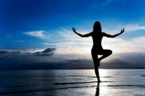 Unimmagine di una donna che pratica yoga, incoraggiata dai benefici dellAyurveda LAyurveda, come parte della cultura indiana, offre unampia gamma di benefici per il benessere mentale e fisico