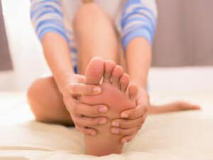 Una donna che si gode un impacco ai piedi con pietre di mare, un trattamento rilassante ed efficace per i piedi secchi