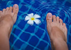 Una donna che massaggia i suoi piedi con una pietra di mare, ideale per un massaggio ai piedi