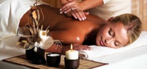 Un massaggiatore estetico sta eseguendo un massaggio vibratorio su un cliente mentre sta confrontando i benefici di un massaggio vibratorio con quelli di un massaggio classico
