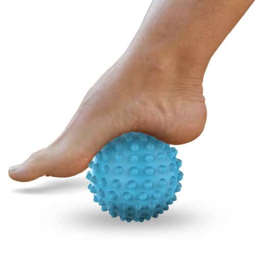 Donna che pratica un massaggio ai piedi con una palla da massaggio, offrendo un sollievo dai dolori e dallo stress