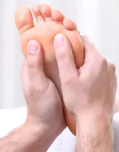 Una persona che riceve un massaggio con le pietre calde sulla pianta del piede, un trattamento benefico per il corpo e la mente