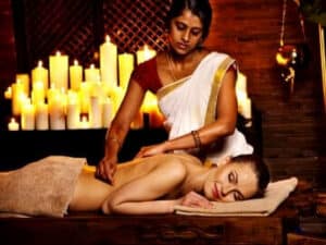 Una foto di un esperto nel massaggio ayurvedico che pratica un massaggio total body per illustrare i benefici della tecnica di massaggio ayurvedico
