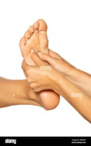Immagine di una mano che regge una pietra di quarzo per massaggiare i piedi scopri come fare un massaggio con le pietre e i cristalli