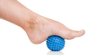 Immagine di un massaggio ai piedi con una palla di gomma una tecnica di rilassamento profondo dei muscoli dei piedi