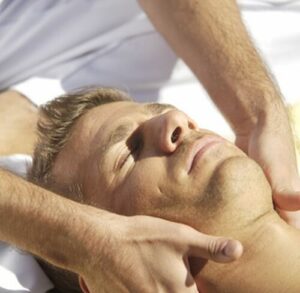 Una foto di una mano che effettua un massaggio cranio sacrale, con il fine di dimostrare i benefici del massaggio cranio sacrale per il sistema del corpo