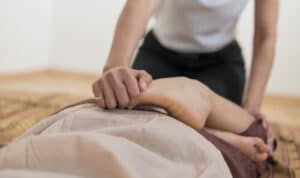 Una persona che pratica yoga riceve un massaggio thai yoga che offre benefici come riduzione dello stress, riduzione della tensione muscolare e miglioramento della flessibilità
